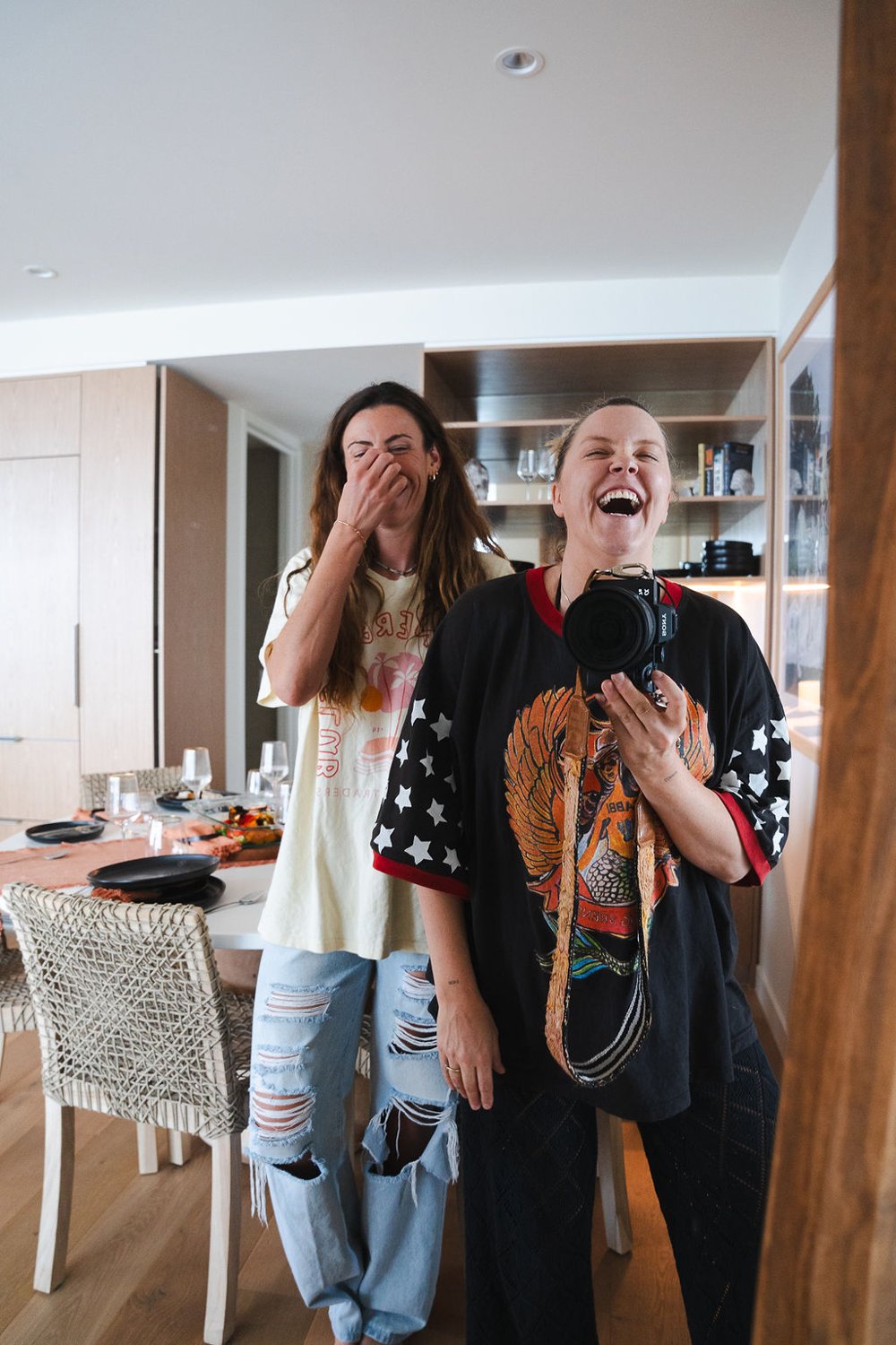 Two members of the team laughing together in a bright, relaxed space.